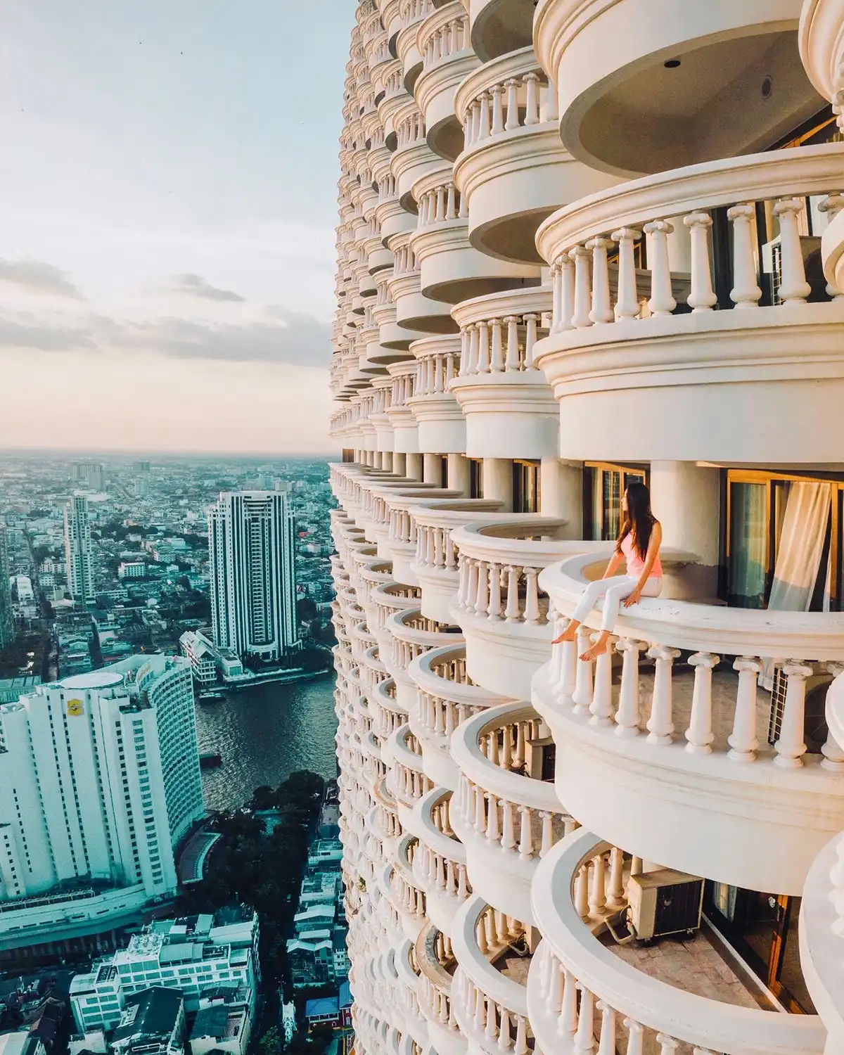 An image of Catherine Tang looking out over a balcony of a tall building.