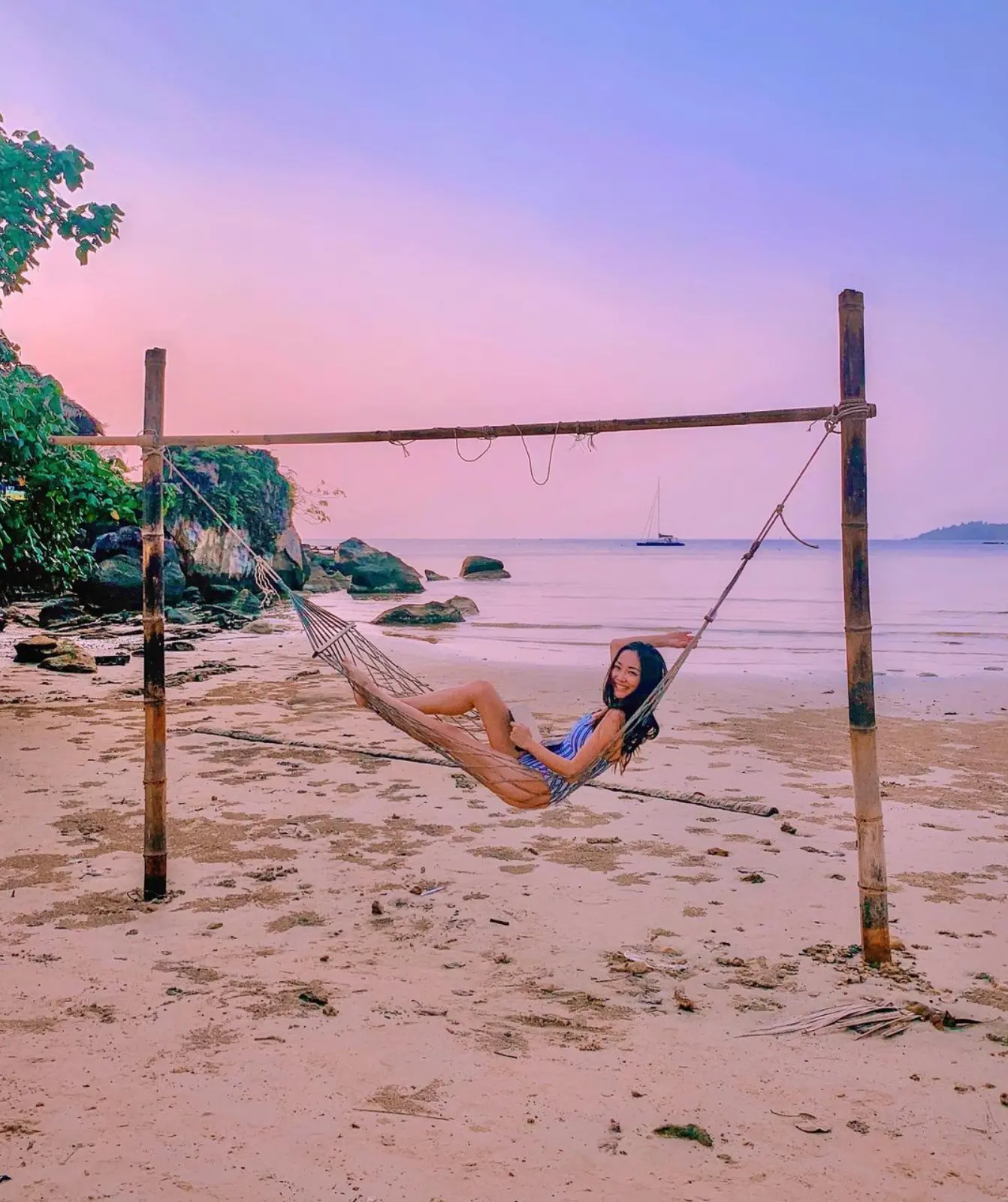 Catherine Tang swinging in a hammock on the beach.